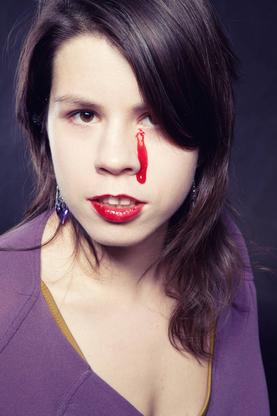 girl in purple straitjacket with bloody tears - Fotó, kép