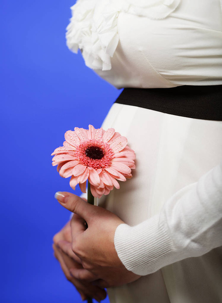 Portrait of the young happy smiling pregnant woman with flower - Foto, Imagen