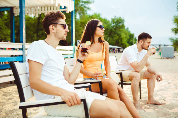 Jóvenes disfrutando de vacaciones de verano tomando el sol en el bar de la playa
 - Foto, Imagen