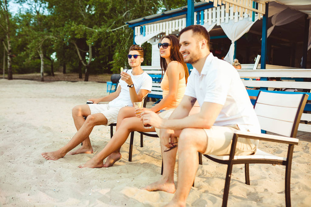 Young people enjoying summer vacation sunbathing drinking at beach bar - Fotoğraf, Görsel
