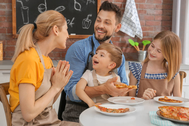 Family eating yummy pizza together in kitchen. Cooking classes concept - Foto, immagini