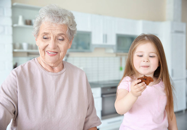 Little girl and grandmother on kitchen - Фото, изображение