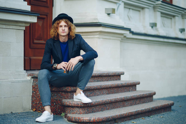 Red haired hipster man sitting on stairs thinking - Photo, Image