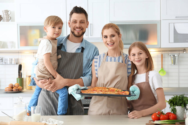 Familie mit Pizza in der Küche. Kochkurskonzept - Foto, Bild