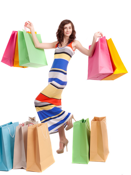 A girl in a long dress color, standing with shopping bags on white background. - Photo, Image