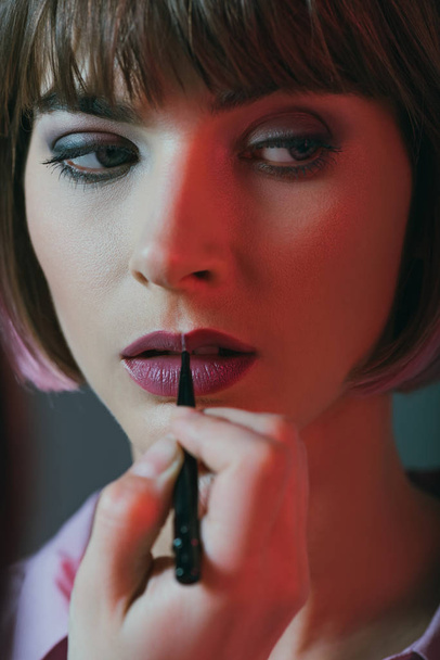 girl applying lipstick - Foto, afbeelding