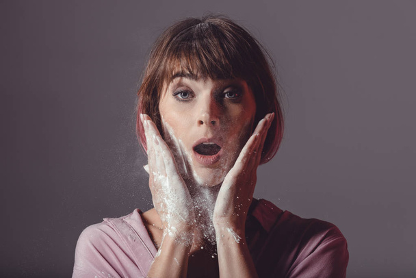 surprised girl with powder on hands - Фото, зображення