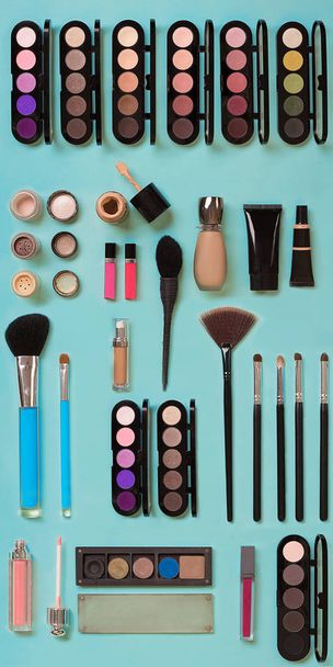 cosmetics for facial makeup: brushes, powder, lipstick, eye shadow, trimmer and other accessories on blue background top view. - Photo, Image