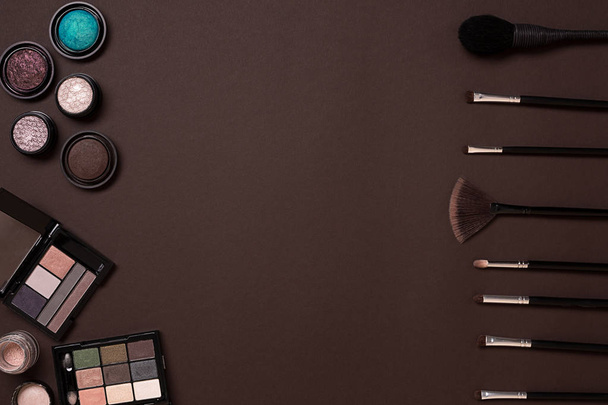 Various cosmetics and brushes on brown background - Photo, Image