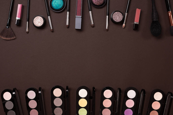 Make up essentials. Set of professional make up brushes, creams and shadows in jars on dark background. - Photo, Image