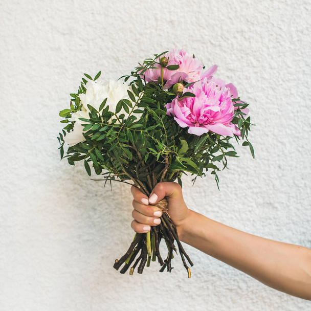 Букет пионских цветов в руке
 - Фото, изображение