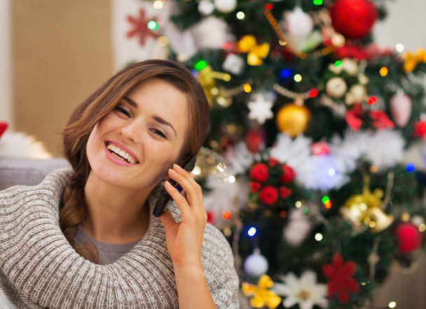 Happy woman near Christmas tree making phone call - Fotó, kép