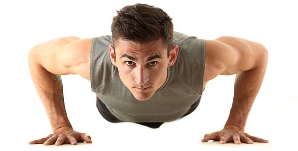 Fitness man wringen van de isoladed van de vloer op wit - Foto, afbeelding