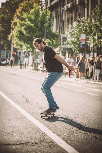 Pro skateboard rider in front of car on city road - Zdjęcie, obraz
