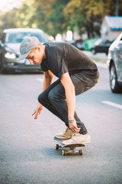 Pro skateboard rider in front of car on city road - 写真・画像