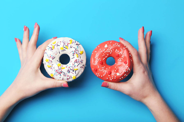 Female hands holding sweet donuts  - 写真・画像