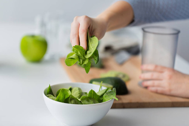 close up of woman hand adding spinach to bowl - Fotografie, Obrázek