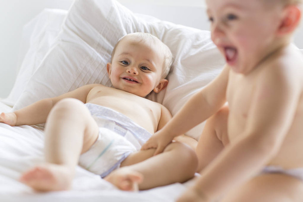 Twin baby boy child play fun in bed - Фото, изображение