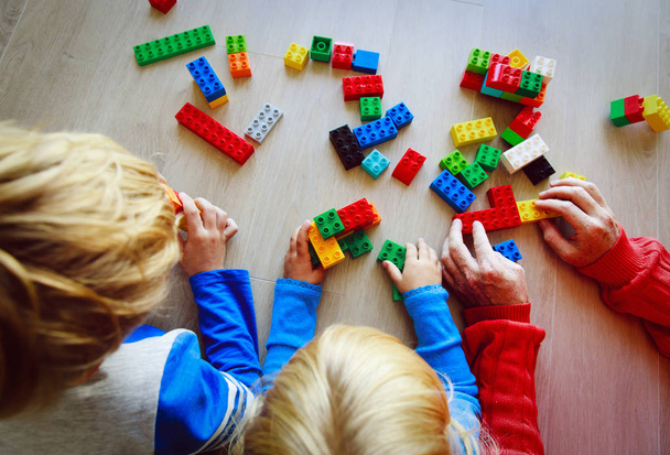 maestro y niños jugando con bloques de plástico
 - Foto, Imagen