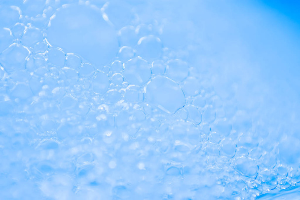 Macro vista espuma de bolhas de sabão branco. suds e textura do chuveiro. Fundo azul. foco suave
 - Foto, Imagem