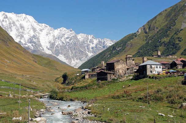 Village caucasien Ushguli sur la rivière entourée de collines
 - Photo, image