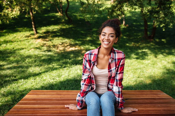Amazing young african woman sitting outdoors in park - Photo, Image