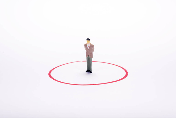 Pienoiskoossa ihmiset, liikemies punaisessa ympyrässä valkoisella taustalla
 - Valokuva, kuva