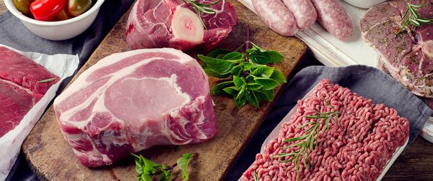 Different types of fresh raw meat on dark wooden background.  - Fotografie, Obrázek