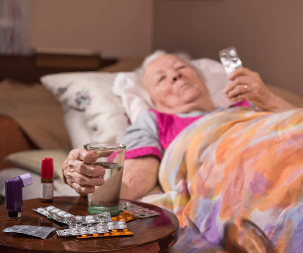  Sairas vanha nainen makaa sängyssä kotona
 - Valokuva, kuva
