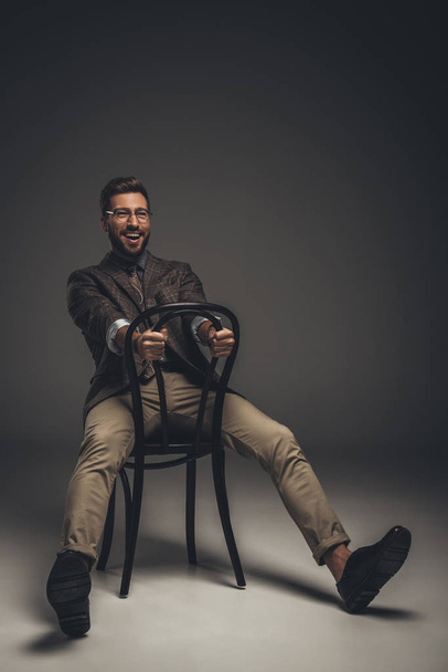 man in suit sitting on chair backwards - Фото, зображення