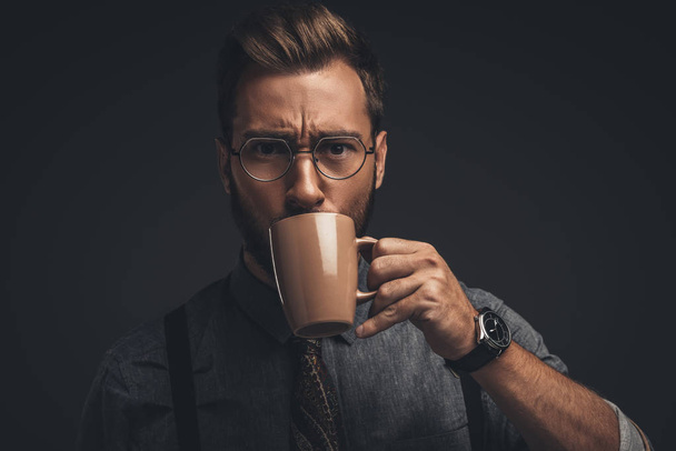 man in glasses drinking from cup - Foto, afbeelding