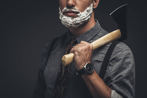 Ο άνθρωπος σε κρέμα ξυρίσματος που κρατάει το τσεκούρι - Φωτογραφία, εικόνα