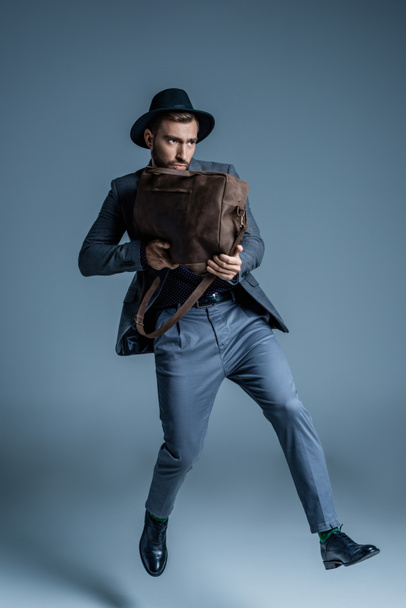 man in suit holding leather bag - Foto, afbeelding