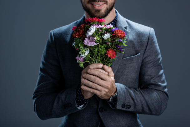 Smiling man holding bouquet - Фото, зображення