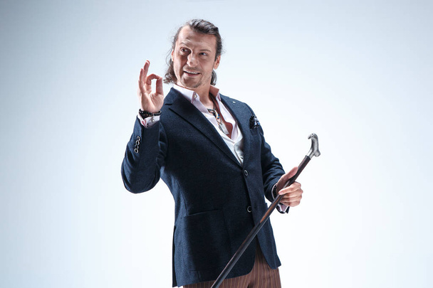 The mature barded man in a suit holding cane. - Photo, Image