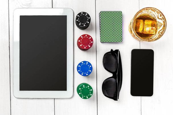 Gokken. Poker chips, kaarten en de dobbelstenen in de buurt van tablet op houten tafel. Bovenaanzicht. Copyspace. Poker - Foto, afbeelding