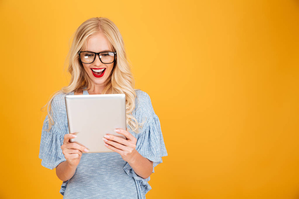 Happy young blonde woman using tablet computer. - Φωτογραφία, εικόνα