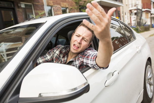 Irritated young man driving a car. Irritated driver - Foto, afbeelding