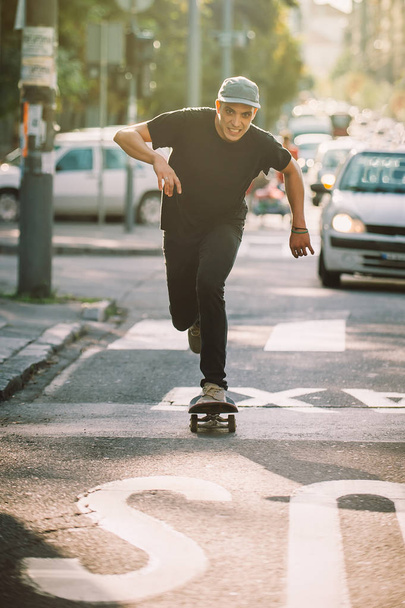 Pro skateboard rider in front of car on city street - Foto, Bild