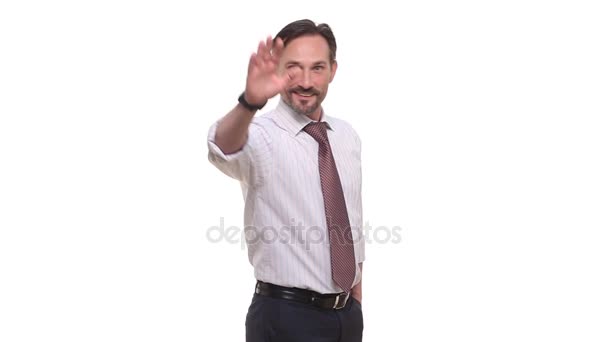 Businessman waving to camera in studio - Felvétel, videó