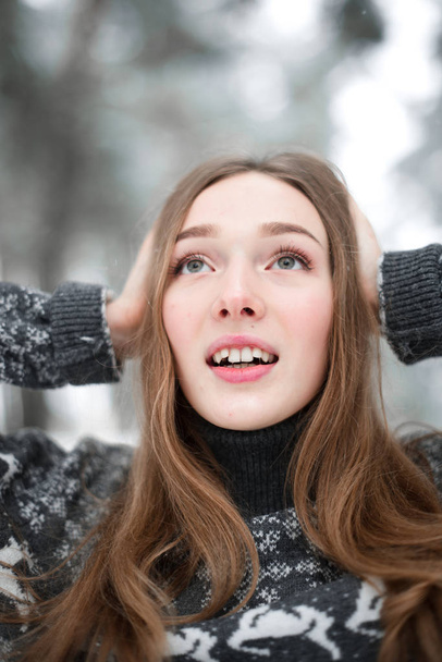 セーターを着て若い美しいブルネットの女性の冬の肖像画。雪の冬の美しさのファッションコンセプト. - 写真・画像