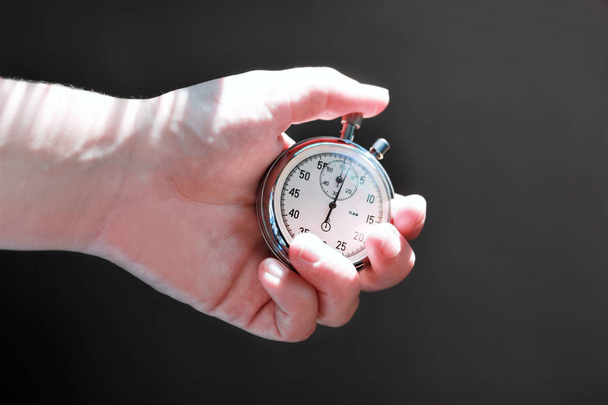 Hand holding een stopwatch en druk op de knop om op te merken van de tijd. - Foto, afbeelding
