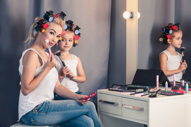 Mother and her child girl are doing your makeup and having fun - Photo, Image