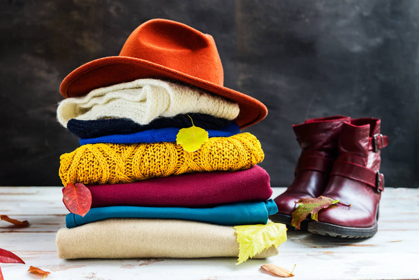Куча разноцветной теплой осенней и зимней одежды
 - Фото, изображение