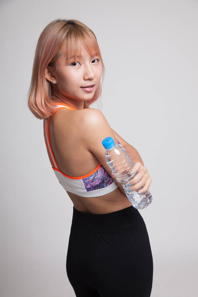 Beautiful Asian healthy girl with bottle of drinking water. - Foto, imagen