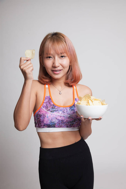 Beautiful Asian healthy girl  eat potato chips. - Фото, зображення