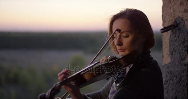 Playing violin in ruined building with sunset 4K. - Footage, Video