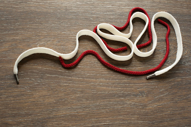 Set of decorative white and red cords on wooden background. - Photo, Image