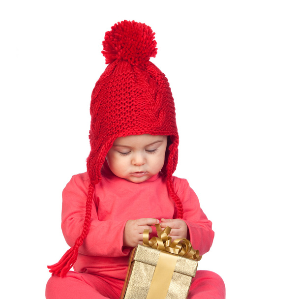 Baby girl with wool hat looking a gift - Photo, Image