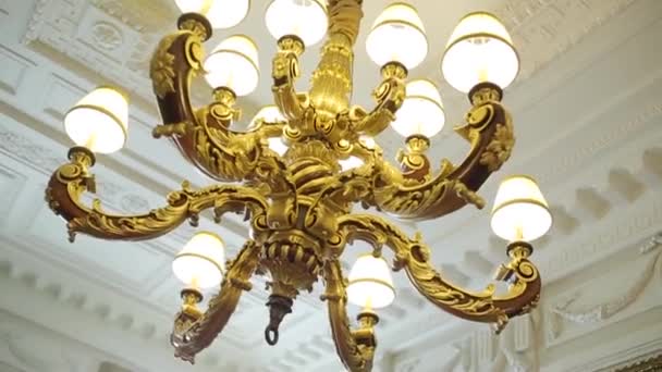 Kroonluchter opknoping onder een plafond in een paleis. Luxe plafond kroonluchter - Video